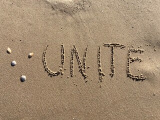 on the beach is carved with letters in the smooth sand the writing unite