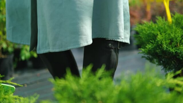 close-up of a woman in boots and a skirt in a plant store, a skirt in the wind