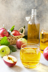 Autumn vitamin drink juice apple. Apple juice in a glass and fresh apples on a stone tabetop.