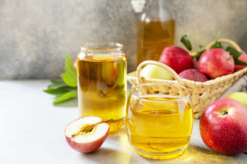 Autumn vitamin drink juice apple. Apple juice in a glass and fresh apples on a stone tabetop. Copy space.
