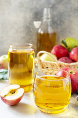 Autumn vitamin drink juice apple. Apple juice in a glass and fresh apples on a stone tabetop.