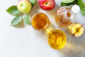 Autumn vitamin drink juice apple. Apple juice in a glass and fresh apples on a stone tabetop. View from above. Copy space.