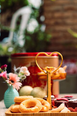 Rosquinhas com sequilhos e doces de chocolate na mesa posta com flores e bolas de natal