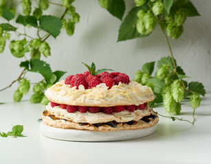 Round meringue pie with fresh raspberries on a white background, Pavlova dessert