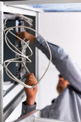 Unrecognizable man installs and connects the Internet cable to the fuse box.