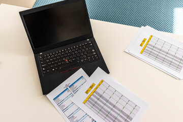 Close up shot of a print outs of excel table of a bank loan amortization table, personal balance sheet and laptop. Banking