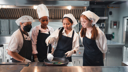 Chef in the kitchen provides cooking training to students.Schoolgirls happily cook...