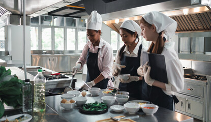 Chef in the kitchen provides cooking training to students.Schoolgirls happily cook together.children wearing cooking uniform.