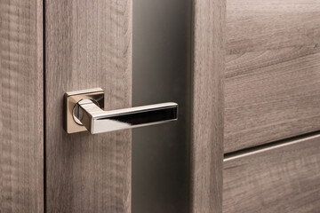 Close up of stylish silver chrome door handle on modern interior door. - obrazy, fototapety, plakaty