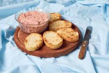 Homemade beef liver pate in a glass jar and baguette slices with pate