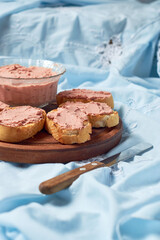 Bread toast with pork liver pâté on a rustic background.