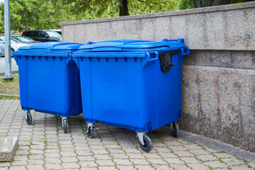 Blue plastic trash recycling containers. Blue containers for collecting garbage on the dustbin.
