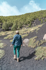 Naklejka premium Woman hiking on Mount Etna. It's a active vulcano in Sicily.