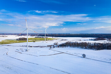 Alternative energy in Poland. Wind turbines on winter snowy field.