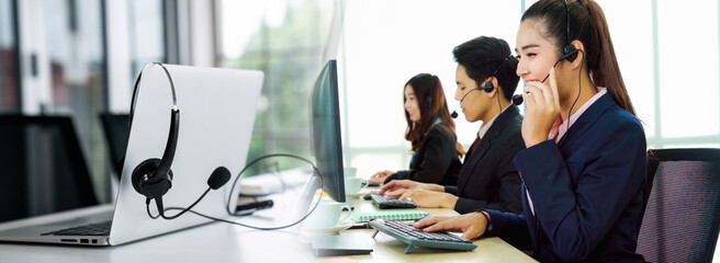 Business people wearing headset working in office in widen view to support remote customer or...