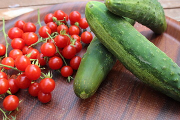 Some tiny cherry tomatoes and green peppers in white plates on wooden concept.