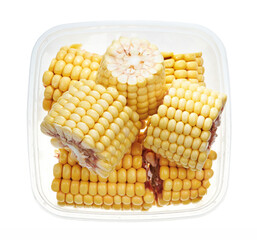Corn cobs in plastic container. Top view of raw vegetables isolated on white background. Preparing vegetables for freezing. Storage for winter storage in trays