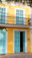 Quaint house with a yellow facade and light blue doors and windows
