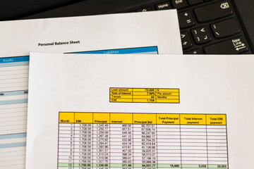 Close up shot of a print outs of excel table of a bank loan amortization table, personal balance...