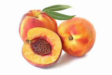 Two whole peaches and half with leaves isolated on white