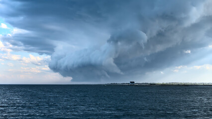 Naklejka na ściany i meble storm over the sea, formation of a tornado on a small house 