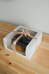 Pastries decorated with blueberries in a cardboard box tied with a ribbon