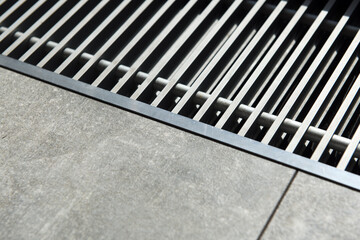 Heating grill with ventilation in the floor in laminate.. Forced hot-air heating systems are extremely popular and feature vents like this to channel the hot air throughout the house.