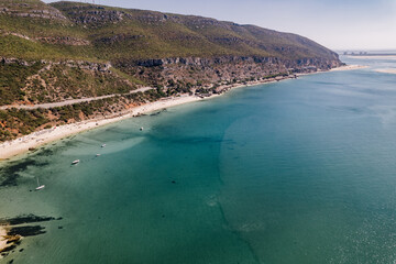 drone photo with sunny beach with people and a big blue ocean and clear sky. A perfect nature holiday day at the sea with boats and trees