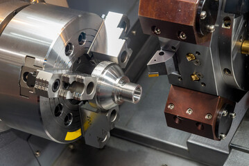 The  CNC lathe machine forming  cutting the metal shaft parts.