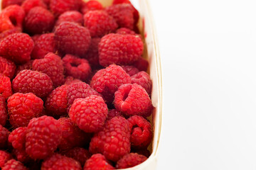 raspberries in a bowl on white background