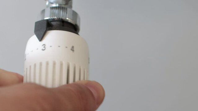 Adjust a thermostatic valve to save energy. Energy saving in domestic heating by reducing the power of radiators with thermostatic valves. Energy efficiency and savings in natural gas consumption