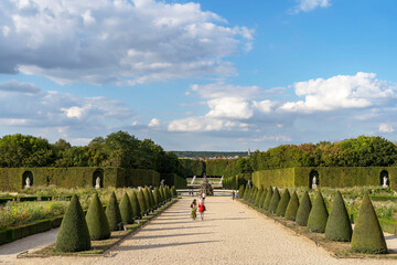 Beautiful gardens of the Palace of Versailles with trimmed trees and shrubs, landscape art of...