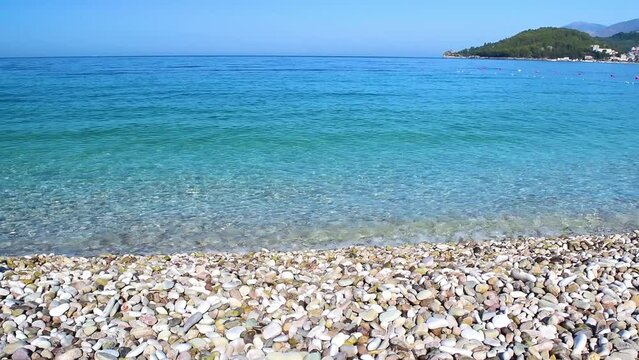 Beautiful pebble beach of Himare town. Ionian sea. Albania. Summer sunny landscape. Concept of summer holidays and relaxation.