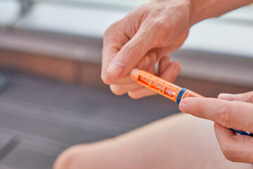 Type 1 Diabetes patient at a swim session with an insulin pen to inject dose syringe and correct...