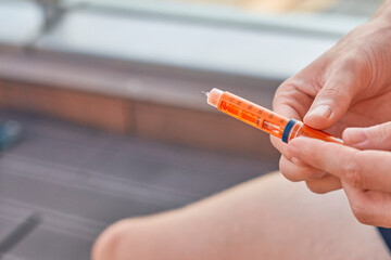 Type 1 Diabetes patient at a swim session with an insulin pen to inject dose syringe and correct...