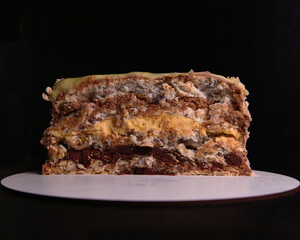 Kyiv cake dessert, dessert cake made in Kyiv. The cake with two airy layers of meringue with hazelnuts, chocolate glaze, and a buttercream-like filling. Cake layers close up.