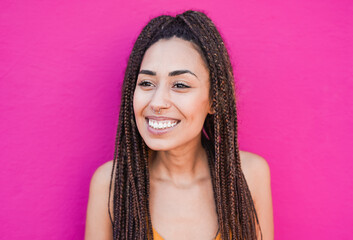 Happy young african girl smiling outdoor with pink wall in the background