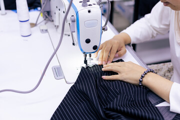 Tailor working on electric sewing machine