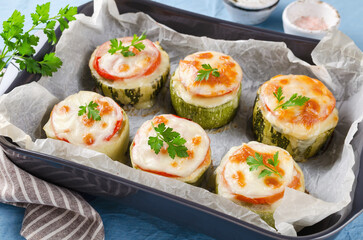 Zucchini stuffed with minced meat and rice, with tomatoes and mozzarella.