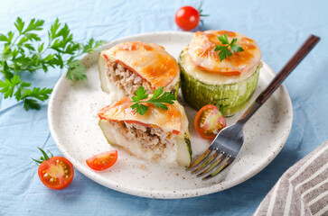 Zucchini stuffed with minced meat and rice, with tomatoes and mozzarella.