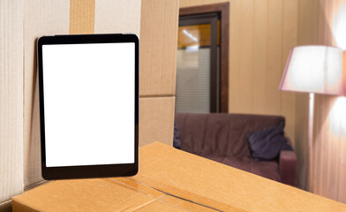 Relocation offer. Tablet computer on boxes. Tablet with blank white screen. Places for advertising relocation services. Tablet for website. Concept relocation things. Selective focus. 3d image