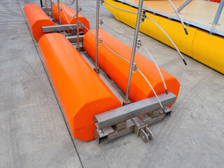 Pontoons with electric cables. Device for laying electrical wires above water. Orange pontoons...