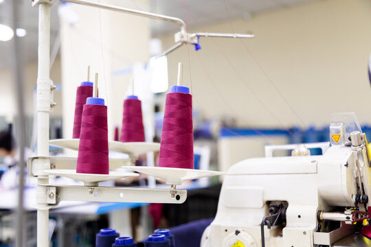 Purple spool of sewing threads unrolling on sewing machine