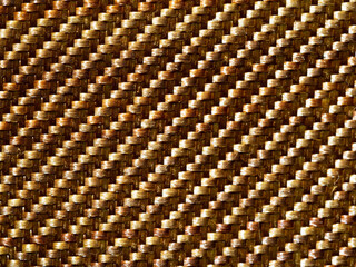 Close up bulletproof material aramid. Aramid kevlar background. Golden kevlar texture and pattern.