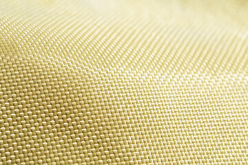 Bulletproof material aramid. Shining aramid kevlar background. Yellow kevlar texture and pattern.