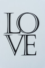 the word love represented with paper (formal font on blank paper)