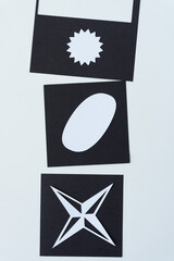 three distinct paper shapes on black squares