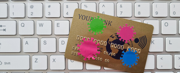 Bank credit card with viruses on keyboard