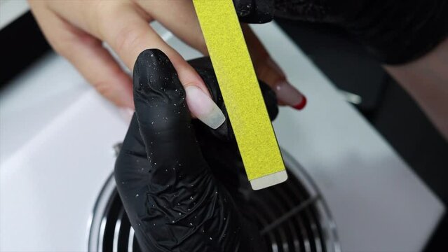Manicurist shape of the nails with a special nail file. 