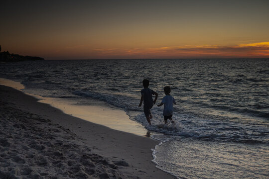 Sarbinowo poland August 2022, unidentfied children play by the Baltic sea in the evening